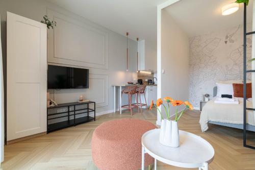 a living room with a bed and a table with flowers at Good Mood Francuska Retreat - FREE PARKING - Self check-in in Katowice