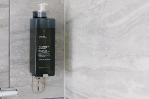 a green bottle of soap is next to a wall at 4 Canon Lane in Chichester