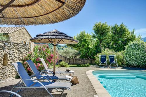 a group of chairs and an umbrella next to a swimming pool at Clos Saint-Michel Resort & Spa in Malaucène