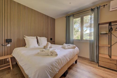 a bedroom with a large bed with towels on it at Clos Saint-Michel Resort & Spa in Malaucène