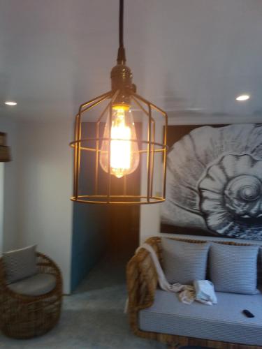 a hanging light in a room with a couch and a chair at The VRNON Boutique by MY hostel in Boracay
