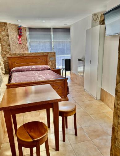 a bedroom with a bed and a table and chairs at A Casa de Santos in Combarro