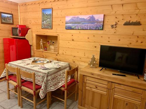 una sala da pranzo con tavolo e TV a schermo piatto di Maison di Viola a Arliod