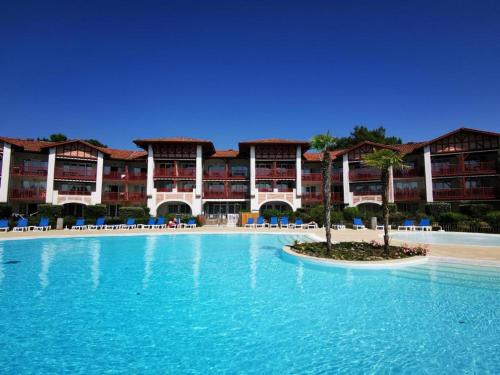 une grande piscine devant un complexe hôtelier dans l'établissement appartement dans résidence du golf proche du lac, à Biscarrosse