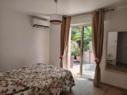 une chambre avec un lit et une porte coulissante en verre dans l'établissement Boulouris entre mer et piscine, à Saint-Raphaël