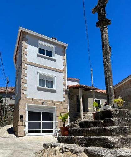 a house with a tree in front of it at A Casa de Santos in Combarro