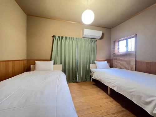 two beds in a room with a window at ～Fushimi Inari～露天風呂付の一棟貸切のゲストハウス in Kyoto