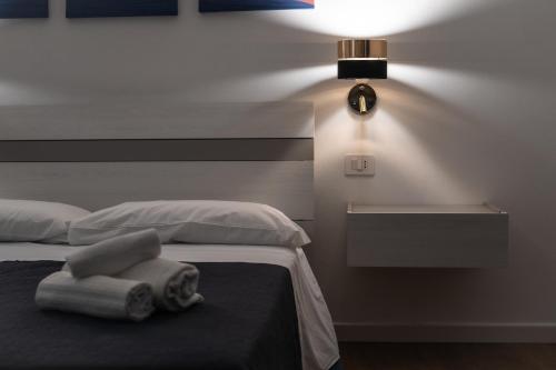 a bedroom with a bed with two towels on it at Vela Rossa Deluxe Apartment in Trapani