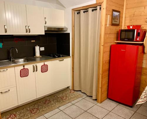 a kitchen with a red refrigerator and a microwave at Maison di Viola in Arliod