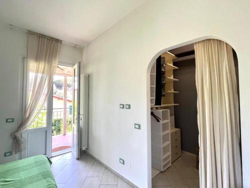 an archway in a room with a door to a room with a window at Pineta Apartament in Tirrenia
