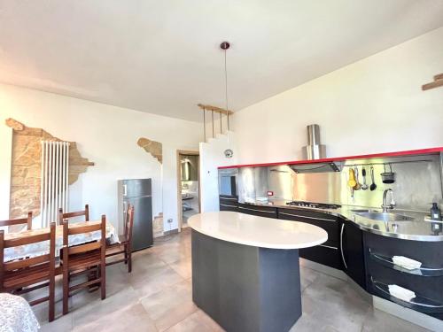 a large kitchen with a table in the middle at Pineta Apartament in Tirrenia