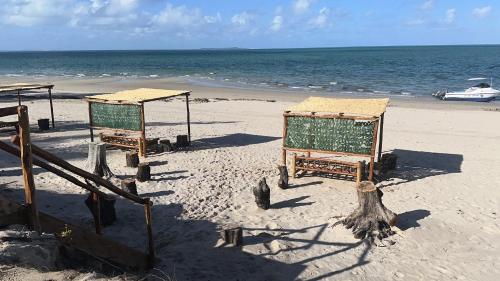 two beds on a beach with the ocean at Telvina Beach Lodge in Vilanculos