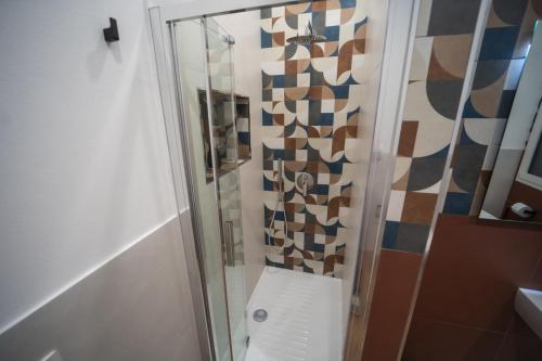 a shower with a glass door in a bathroom at Vela Rossa Deluxe Apartment in Trapani