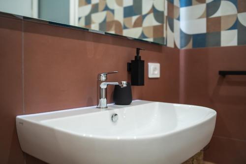 a white sink in a bathroom with a mirror at Vela Rossa Deluxe Apartment in Trapani