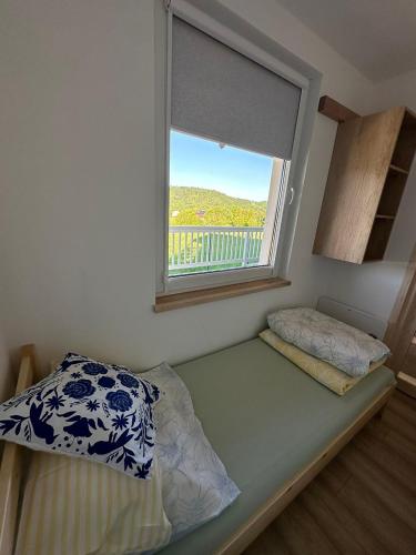 a small bedroom with a window and a bed at domki-sopotnia in Sopotnia Wielka