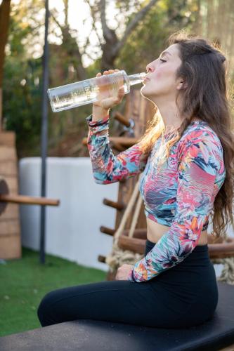 a woman drinking a bottle of water at Elbitat Homes in Bagnaia