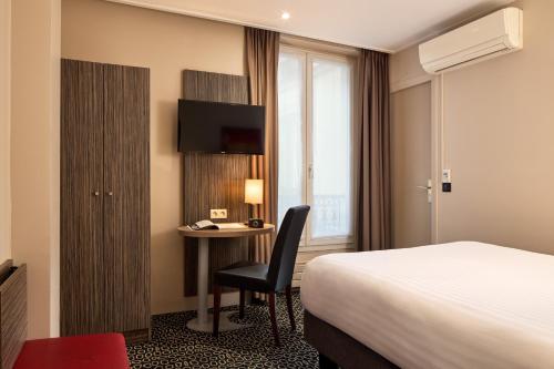 a hotel room with a bed and a desk with a computer at Timhotel Odessa Montparnasse in Paris