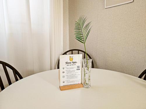 a book sitting on a table with a vase on it at Honey Sleep Room - 2BR Cosy House at Jamsil, FreeParking in Seoul