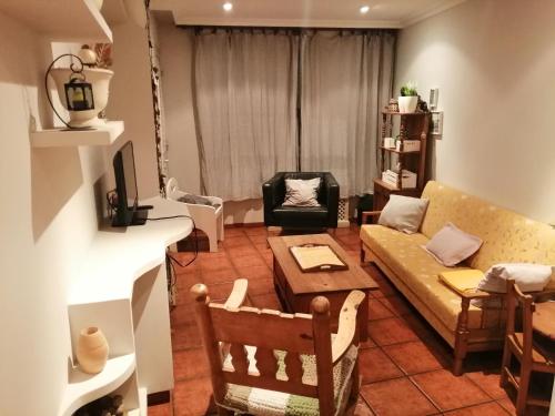 una sala de estar con un sofá y una mesa en O Piso dos Avós, en A Guarda