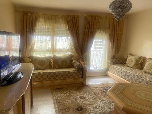 un salon avec un canapé et deux fenêtres dans l'établissement la maison, à Pantin