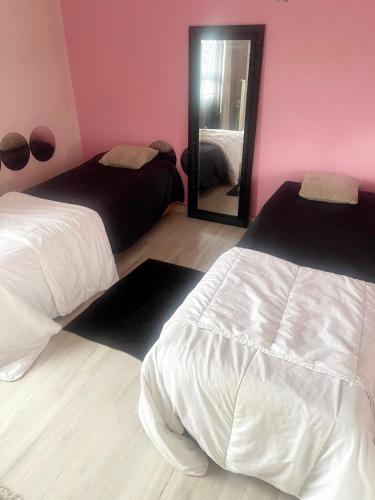 une chambre avec deux lits et un miroir dans l'établissement la maison, à Pantin