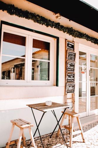 a table and two stools in front of a building at Cascais, Vila Bicuda in Cascais