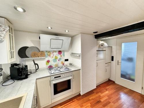 a kitchen with white cabinets and a stove top oven at Fachwerkhaus im Landhausstil in Staufenberg