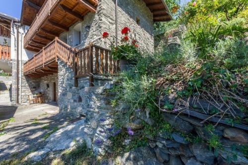 a stone house with a balcony and flowers at Il Nido di Letizia in Châtillon