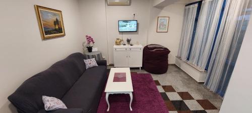 a living room with a couch and a table at Stan CENTAR u Stocu in Stolac