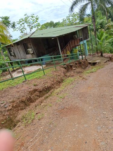 a small house with a roof on the side of a dirt road at El Tesoro del Sir Hotel y Restaurante in Rancho Quemado