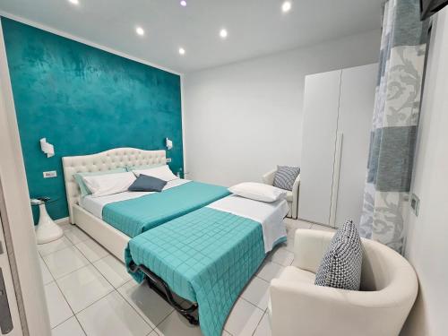 a bedroom with a bed and a chair at Serenis Luxury Apartments in Minori