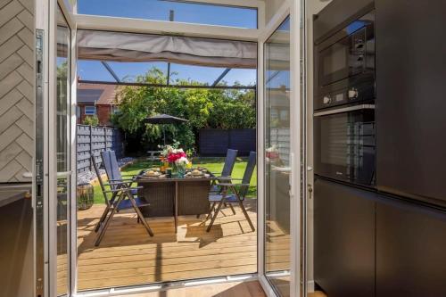 a sliding glass door leading to a patio with a table and chairs at The Dodsworth modern 4 bedroom house, sleeps 8 in York