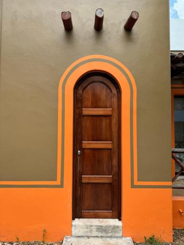 an orange and brown building with a wooden door at Cabañas Manglares in Celestún
