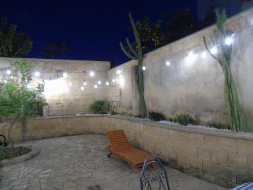a wooden bench sitting on a patio at night at Messer Salentino in Barbarano