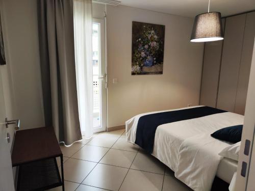 a bedroom with a bed and a window at Casa Renoir - Schritte zum Zee in Locarno