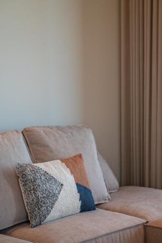 a couch with a pillow on it in a living room at Noema Luxury Retreat Villas - Adults only in Kos Town