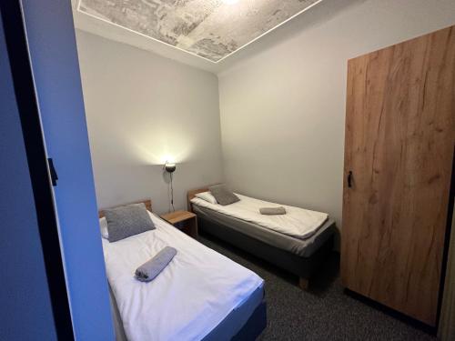 a small room with two beds and a door at Apartamenty Rycerskie in Inowłódz