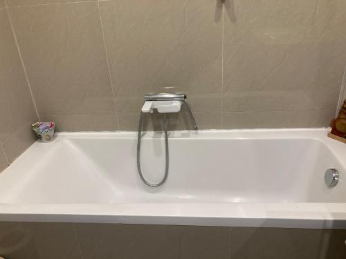 une baignoire blanche avec douche dans une salle de bain dans l'établissement Grand 4 pièces Bourgeois Familial, à Nice