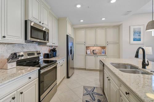 a kitchen with white cabinets and stainless steel appliances at Last Mango in Bradenton
