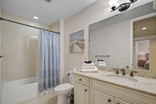 a bathroom with a sink and a toilet and a mirror at Last Mango in Bradenton