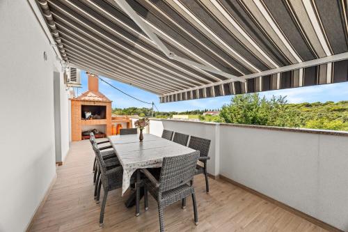 a dining room with a table and chairs on a balcony at Apartman Punta Verudella in Pula
