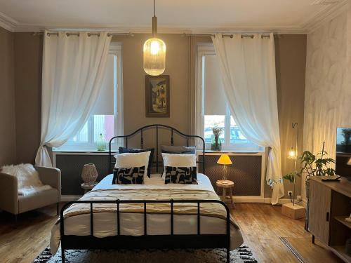 a bedroom with a bed and a couch and windows at Relais Saint-Jean Levroux in Levroux