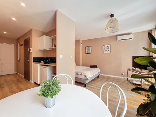 Il comprend un salon avec une table blanche et une cuisine. dans l'établissement Joli Appartement - Hyper Central & Climatisation - Les Frères de la Loc', à Marseille