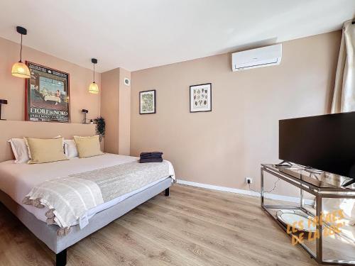 une chambre avec un lit et une télévision à écran plat dans l'établissement Joli Appartement - Hyper Central & Climatisation - Les Frères de la Loc', à Marseille