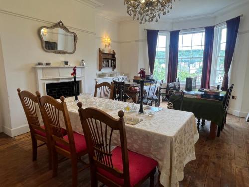 a dining room with a table with chairs and a fireplace at Croft House Apartments in Hastings