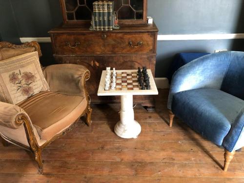 a living room with a chessboard and two chairs at Croft House Apartments in Hastings