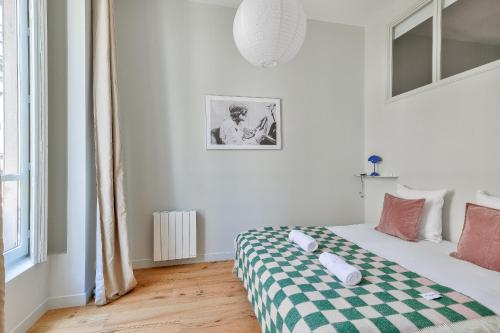 une chambre avec un lit avec une couverture à carreaux dans l'établissement NOCNOC L'Athos, à Lyon