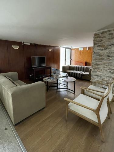 a living room with a couch and a tv at Hotel Tehuelche in Esquel