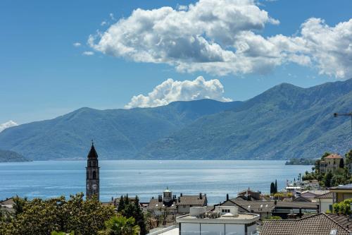 a view of a town and a lake with mountains at Suite Stays by Hotel La Perla in Ascona