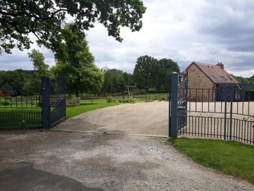 an open gate to a park with a playground at Gite de la Houssière in Joué-du-Bois